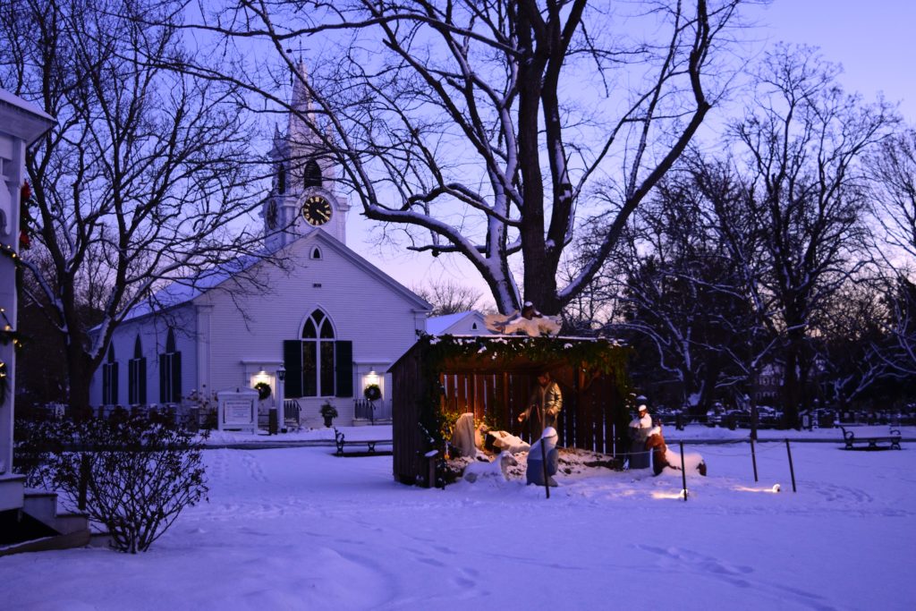 church in snow with manger scene in foreground